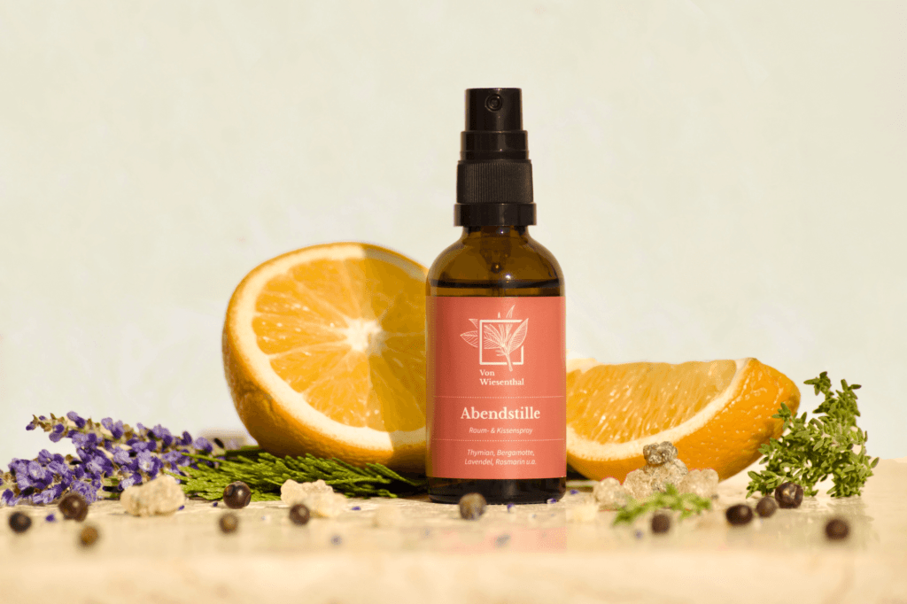 Das mediterrane Raum- und Kissenspray Abendstille vor seinen Zutaten Orange, Weihrauch, Thymian, Lavendel, Wacholder u.a.